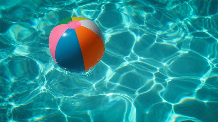 Colorful beach ball floating in water