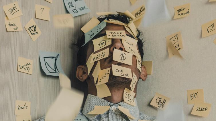 Person standing in corner with stickie notes all over themself and the walls